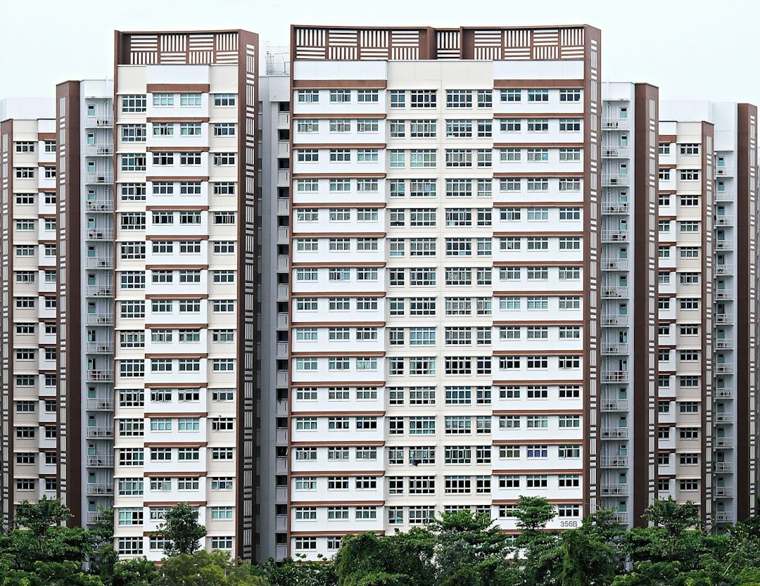 Modern condominium facade along Upper Bukit Timah with mature trees